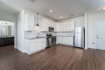a kitchen with white cabinets and a stainless steel refrigerator